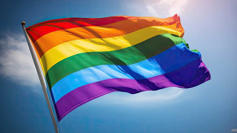 LGBT pride flag and blue sky background